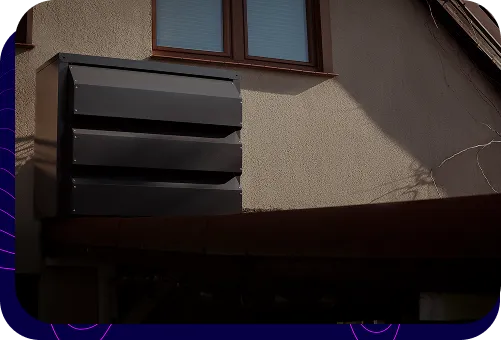 Nowoczesna, ciemna obudowa akustyczna Silencions s|AC| zamontowana na ścianie budynku mieszkalnego, zakrywająca jednostkę zewnętrzną klimatyzatora.