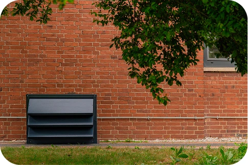 Nowoczesny budynek hotelowy z wyciszoną pompą ciepła w otoczeniu zieleni, podkreślający ciche i estetyczne rozwiązania dla branży hotelowej.