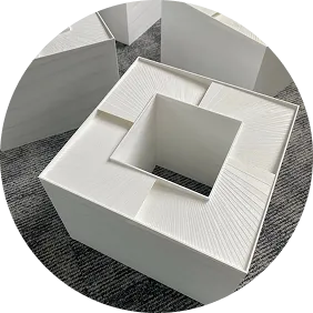 Zdjęcie przedstawia personalizowane, białe, kwadratowe tłumiki akustyczne do wentylacji, wykonane w technologii druku 3D.