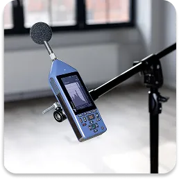 Profesjonalny miernik poziomu dźwięku zamocowany na statywie, gotowy do przeprowadzenia dokładnych pomiarów akustycznych w terenie.