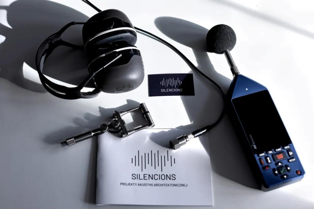 Profesjonalny sprzęt Silencions wykorzystywany do pomiarów akustycznych: miernik poziomu dźwięku, słuchawki i materiały firmowe.