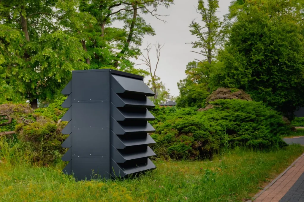 Obudowa akustyczna do pompy ciepła z lamelami, w ogrodzie.