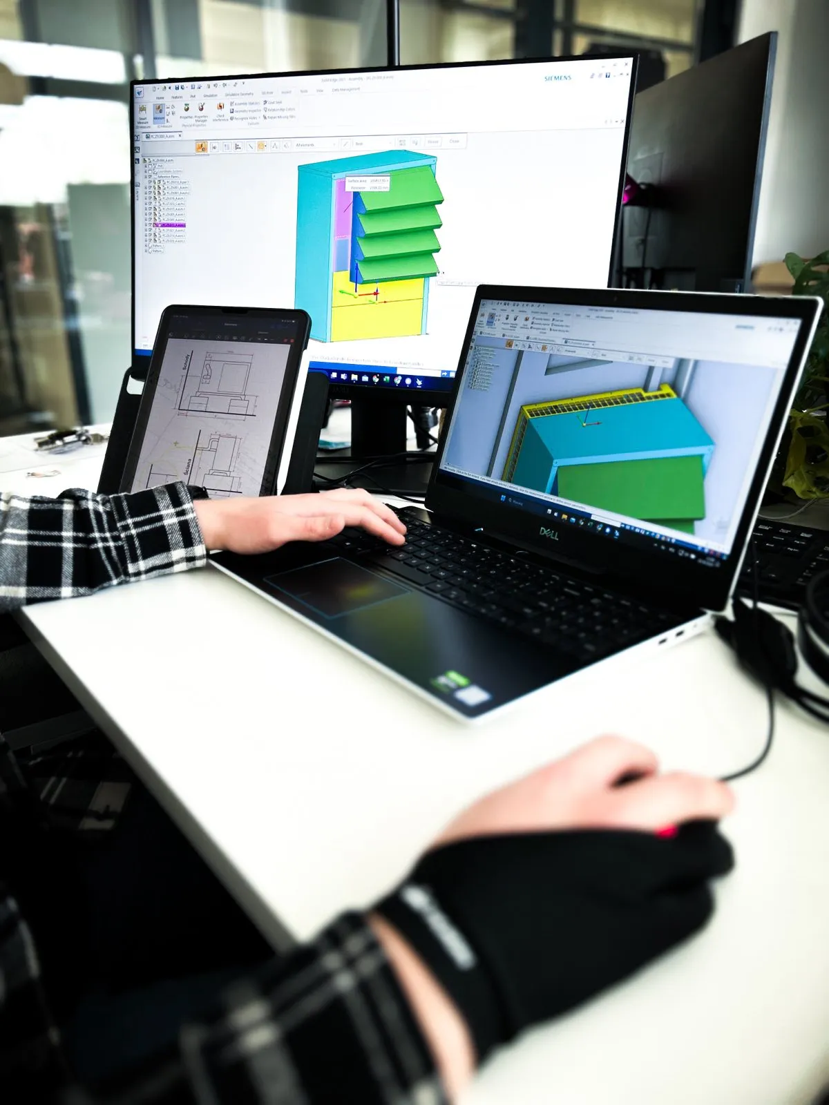 Inżynier Silencions pracujący w programie nad projektem obudowy na pompę ciepła; na ekranach laptopa i monitora widoczny model 3D oraz rysunek techniczny.